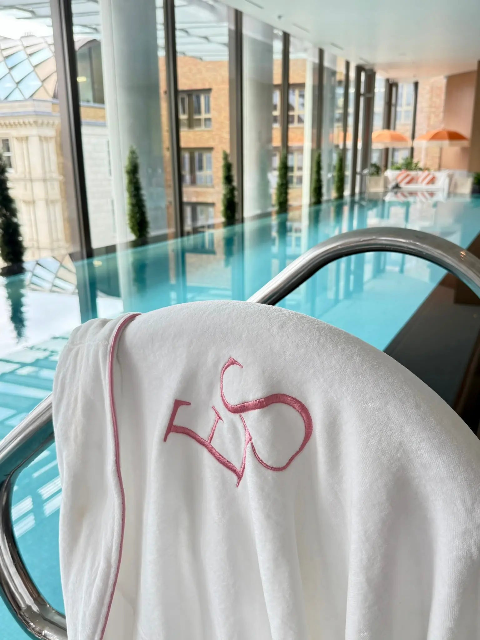 EXOTIC SKN® embroidered robe beside the pool