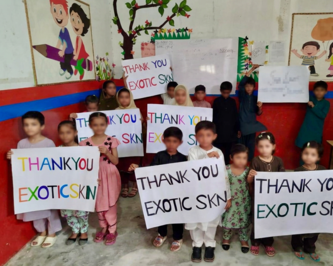 Children holding thank-you signs during the 2025 EXOTIC SKN FOUNDATION® campaign in Pakistan