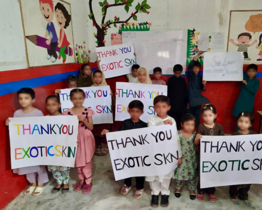 Children holding thank-you signs during the 2025 EXOTIC SKN FOUNDATION® campaign in Pakistan